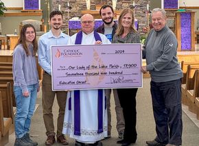 Bill Steger (Foundation Board Treasurer, right) and Lisa Louis (Executive Director) present grant check to Our Lady of the Lake Parish pastor Father Mark Hoffman and FOCUS missionaries who helped lead the SEEK conference: Piper Daleiden (left), Christian