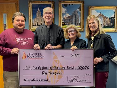 Lisa Louis (Executive Director, right) and Ruthanne Beighley (Foundation Board Member) present grant check to The Epiphany of the Lord Parish pastor Father Jeffrey Lucas and Sergio Cortes Lacayo (Director of Youth Faith Formation and Youth Minister).